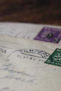 Zwei alte Briefe mit finnischen Briefmarken und handgeschriebener Adresse, im Fokus liegt ein grüner SUOMI-Stempel.